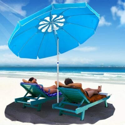 Two people relaxing under blue flower beach umbrella