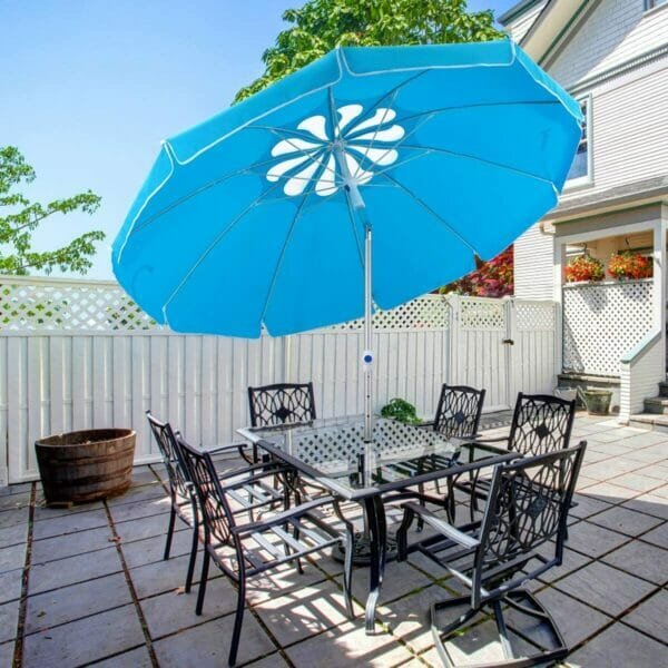 Blue beach umbrella with patio table and chairs