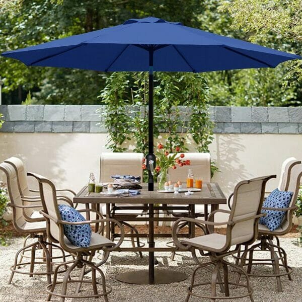 Dark blue patio umbrella in a garden with tables and chairs