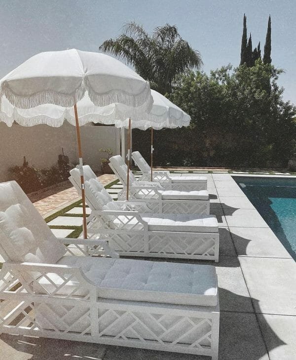 A 5.5 Ft Fringe Cotton Beach Umbrella next to a pool.