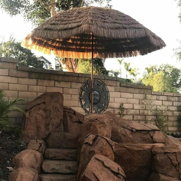 an umbrella sitting on top of a rock