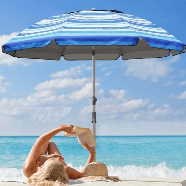 a person sitting at a beach umbrella next to a pool of water