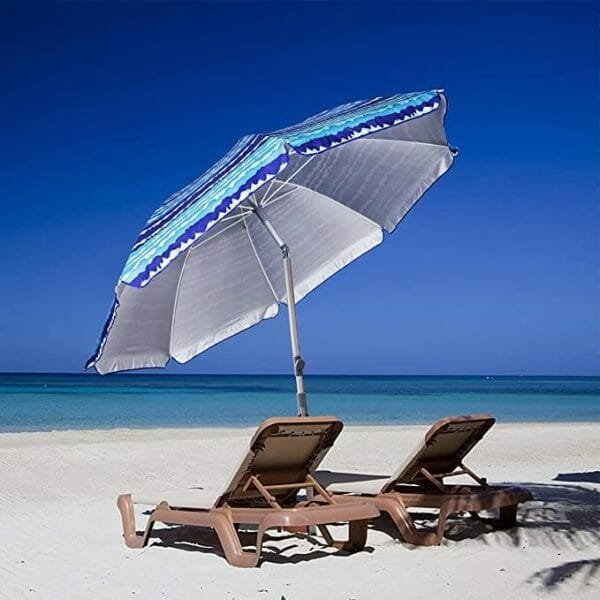 a couple of lawn chairs sitting on top of a sandy beach