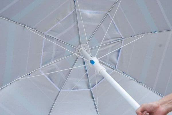 A person holding an ARDECO Polyester with UV Protection Beach Umbrella with a blue handle.