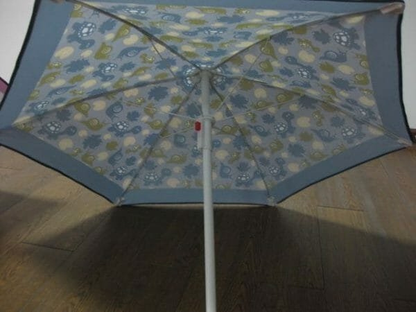 A 1.2M Polyester Beach Umbrella on a wooden floor.