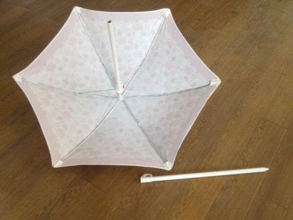 A 1.2M Polyester Beach Umbrella with a white handle on the floor.