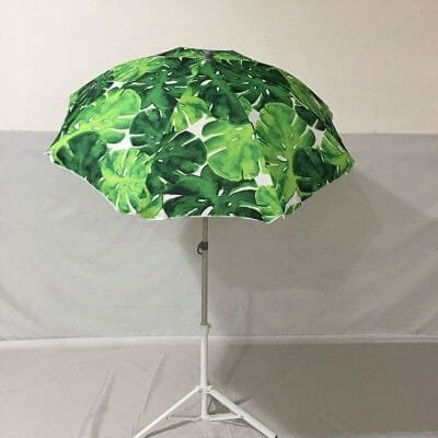 A white 1.8mm Double Layer Polyester Beach Umbrella with green leaves on it.