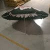An 1.8M Polyester Black & Yellow Beach Umbrella with flowers on it sitting in a warehouse.