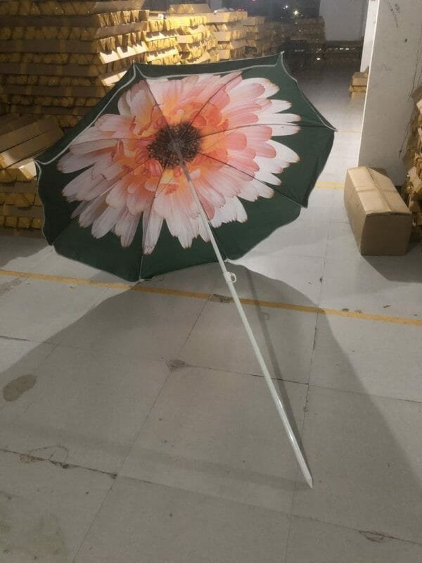 1.8M Polyester Black & Yellow Beach Umbrella with a flower on it sitting in a warehouse.