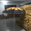 A 1.8M Polyester Black & Yellow Beach Umbrella in a warehouse with a fire design on it.