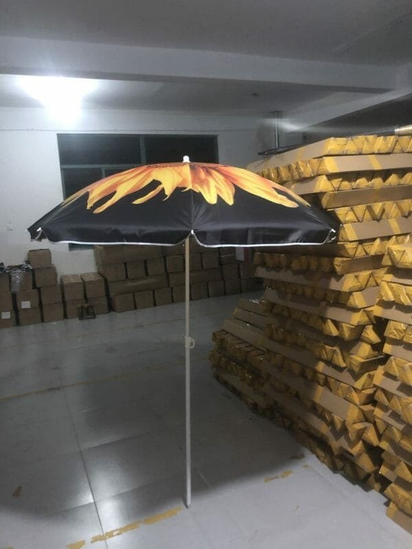 A 1.8M Polyester Black & Yellow Beach Umbrella in a warehouse with a fire design on it.