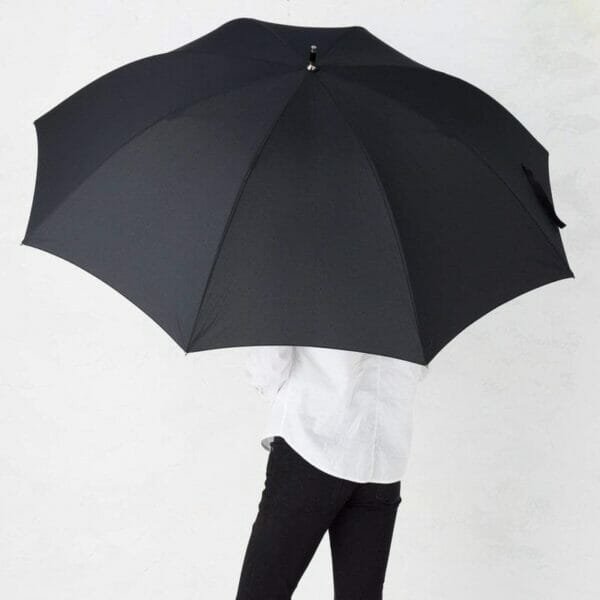 A woman holding a 30inch Cheap Golf Umbrella Pongee in front of a white wall.