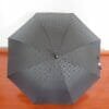 A 27in Aluminum Single Layer Auto Golf Umbrella sitting on a wooden floor.