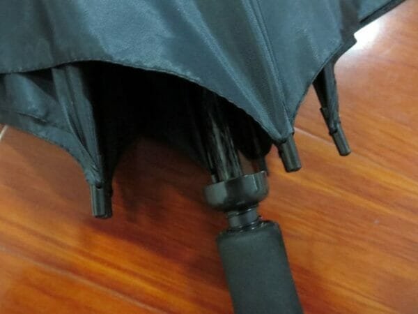 A 27inch Manual Open Golf Umbrella on a wooden floor.