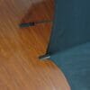 A 27inch Manual Open Golf Umbrella sitting on a wooden floor.