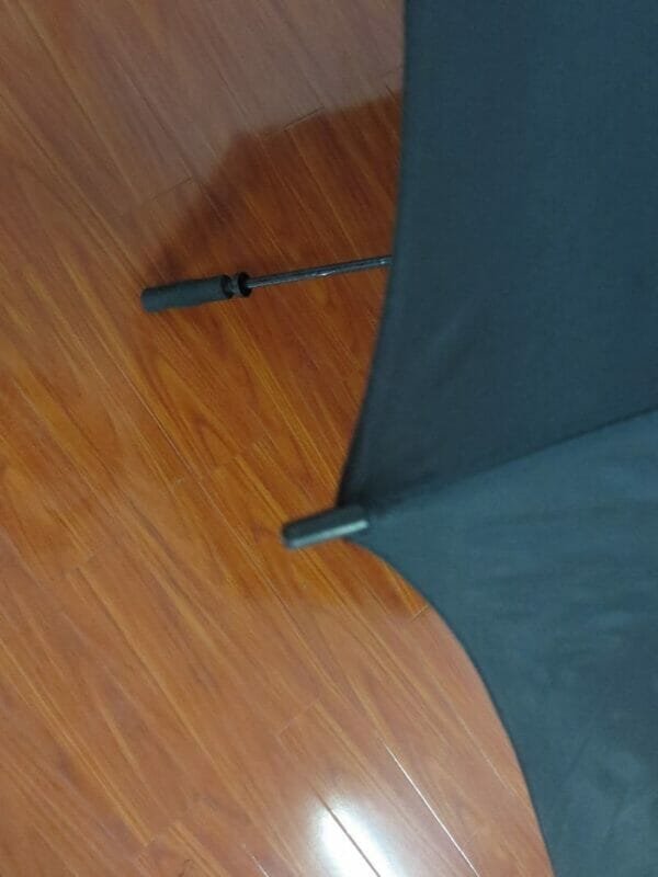 A 27inch Manual Open Golf Umbrella sitting on a wooden floor.