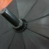 A 27inch Manual Open Golf Umbrella on a wooden floor.