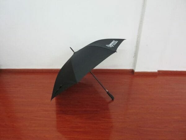 A 25inch Cheap Golf Umbrella sitting on a wooden floor.