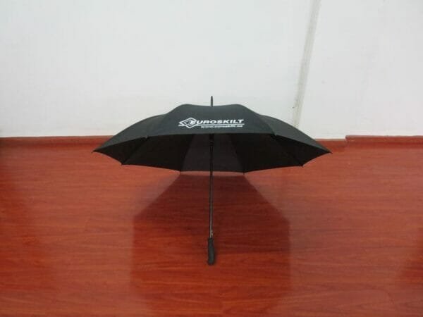 A 25inch Cheap Golf Umbrella sitting on a wooden floor.