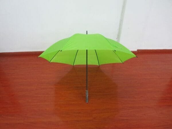 A 27inch Cheap Golf Umbrella sitting on a wooden floor.