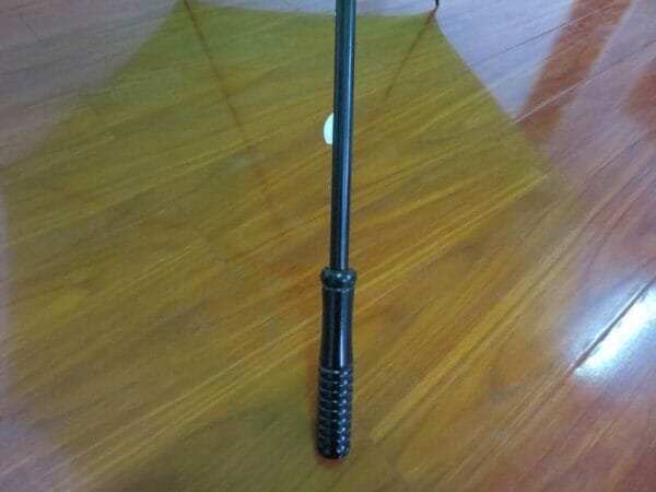 A 27inch Cheap Golf Umbrella sitting on a wooden floor.