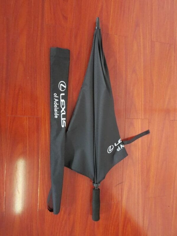 A 30inch Manual Open Golf Umbrella on a wooden floor.