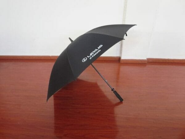 A 30inch Manual Open Golf Umbrella sitting on a wooden floor.