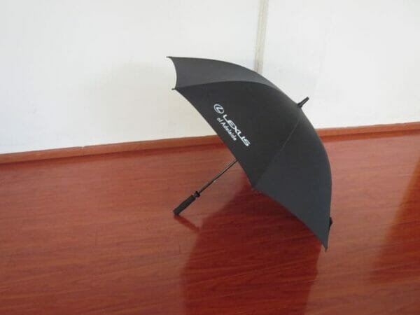 A 30inch Manual Open Golf Umbrella sitting on a wooden floor.