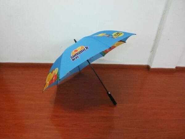 A 30in Single Layer Auto Golf Umbrella sitting on a wooden floor.