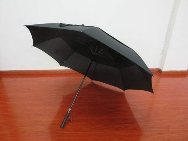 A 30inch Double Layer Golf Umbrella sitting on a wooden floor.