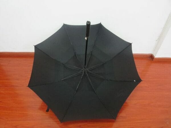 A 30inch Double Layer Golf Umbrella sitting on a wooden floor.