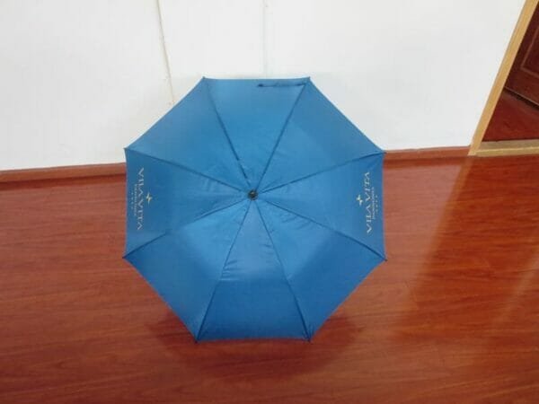 A 25in Single Layer Auto Golf Umbrella sitting on a wooden floor.