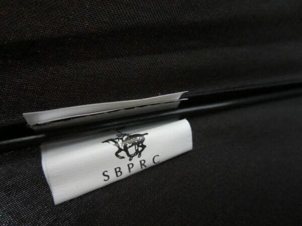 A black 27inch Fold Golf Umbrella with a label on it that says sbrc.