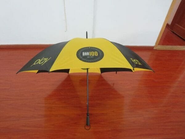 A yellow and black 30inch Cheap Golf Umbrella on a wooden floor.