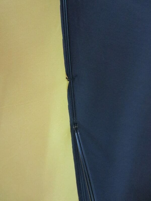 A close up of a 30inch Cheap Golf Umbrella on a yellow wall.