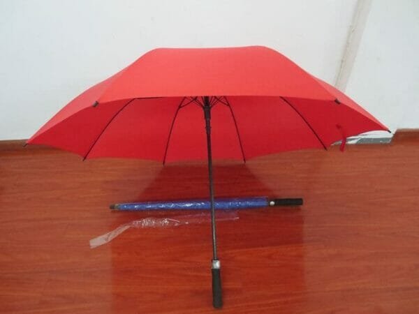 A 30in Single Layer Auto Golf Umbrella Plain is sitting on a wooden floor.