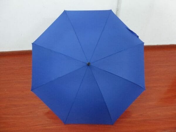 A 30in Single Layer Auto Golf Umbrella Plain sitting on a wooden floor.