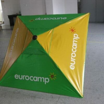 A green and yellow 1.25m PVC Beach Umbrella with the word eurocamp on it.