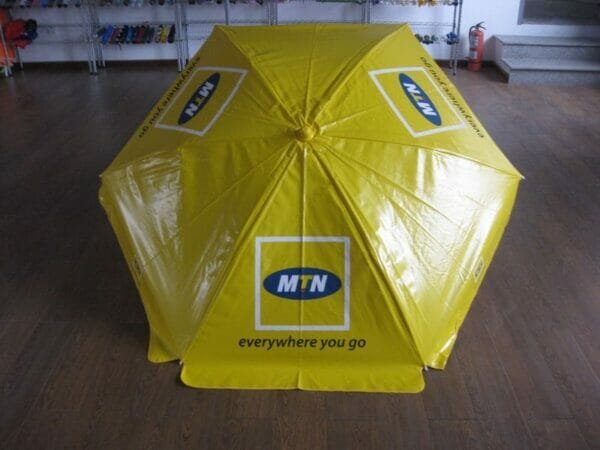 A yellow 1.6m PVC Beach Umbrella with the word mtn on it.