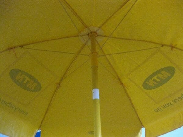 A yellow 1.6m PVC Beach Umbrella with a logo on it.