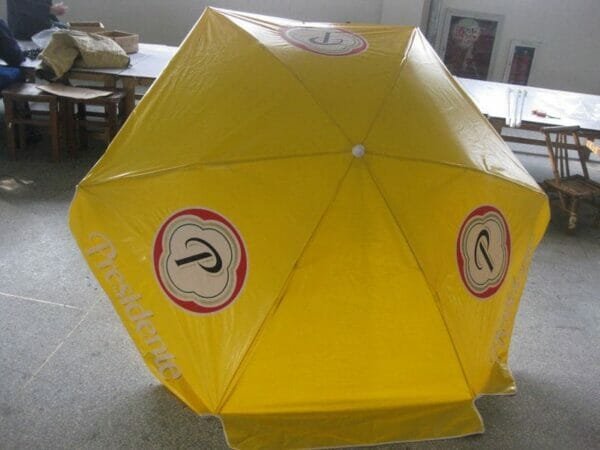 A 1.6m PVC Beach Umbrella is sitting on a table in a room.