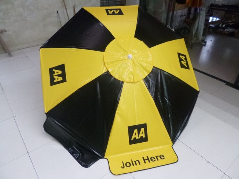 A yellow and black umbrella sitting on a tile floor.