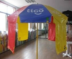 A 1.8m PVC beach umbrella in a room with a sign on it.