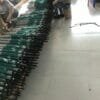 A group of people are working in a warehouse with a lot of 30inch Double Layer Golf Umbrella UV Coated umbrellas.