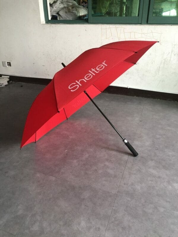 A 30in Single Layer Auto Golf Umbrella Printed sitting on a floor in a room.