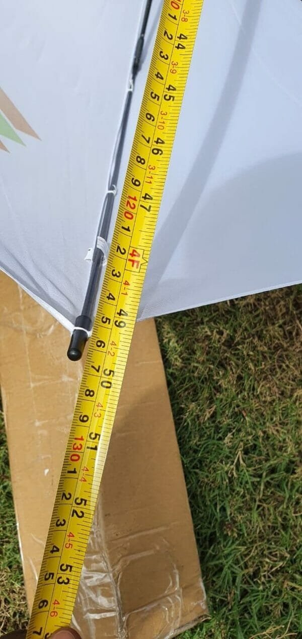 A person is measuring the length of a 23in/30in Single Layer Auto Golf Umbrella.