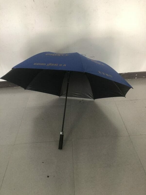 A 30in Black Single Layer Auto Golf Umbrella sitting on a floor.