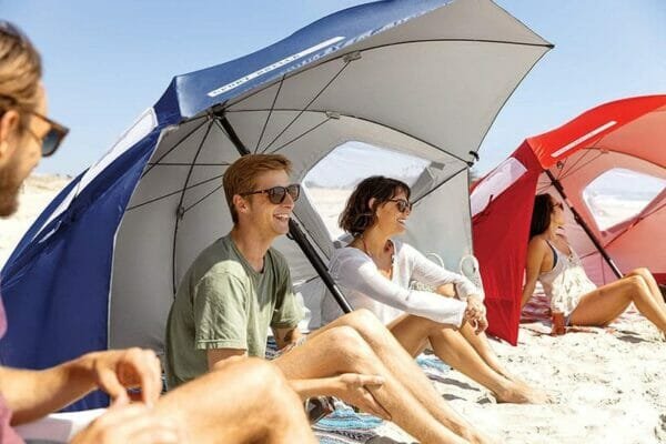 a group of people sitting at a beach umbrella