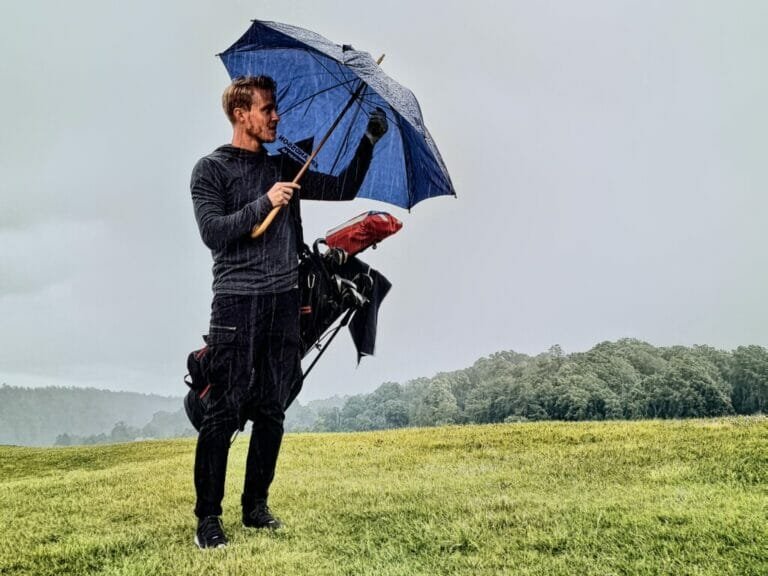 a man holding a umbrella in a field